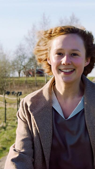 ie 16-jährige Astrid (Alba August) fährt mit dem Fahrrad durch eine ländliche Gegend, an Pferdekoppeln vorbei und strahlt über das ganze Gesicht.