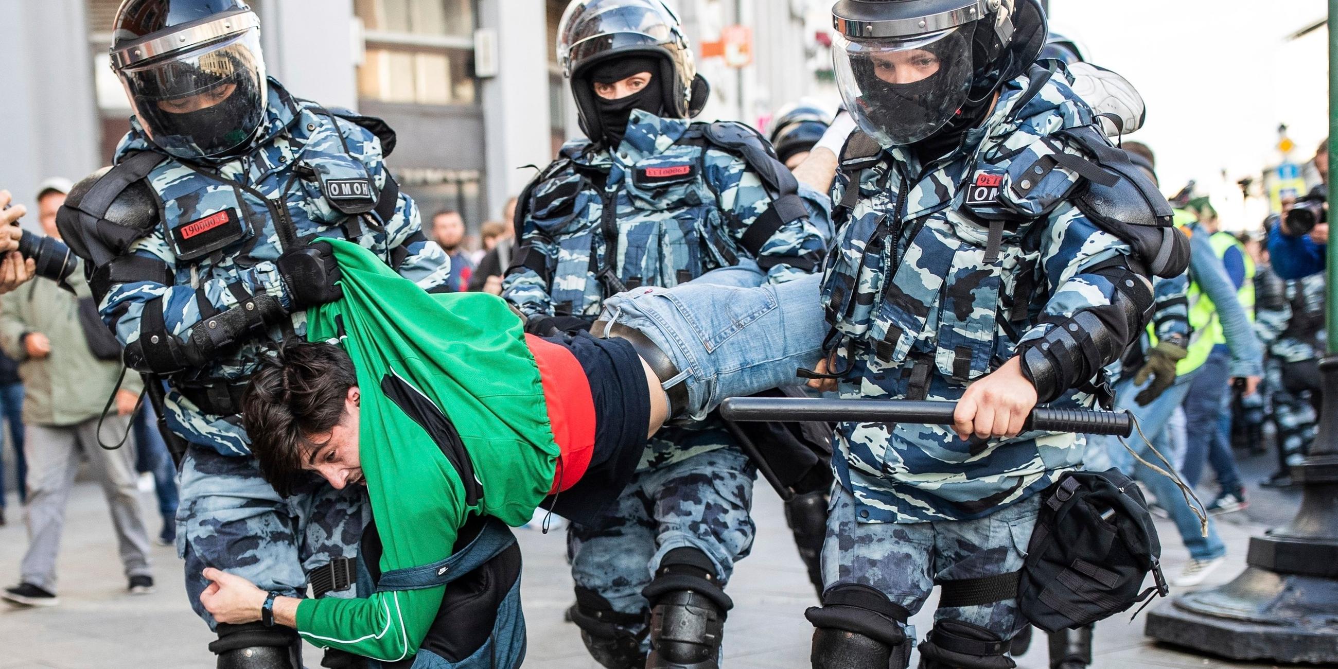 Russland, Moskau: Ein Teilnehmer einer Protestdemo wird von 3 Polizisten weg getragen. Archivbild