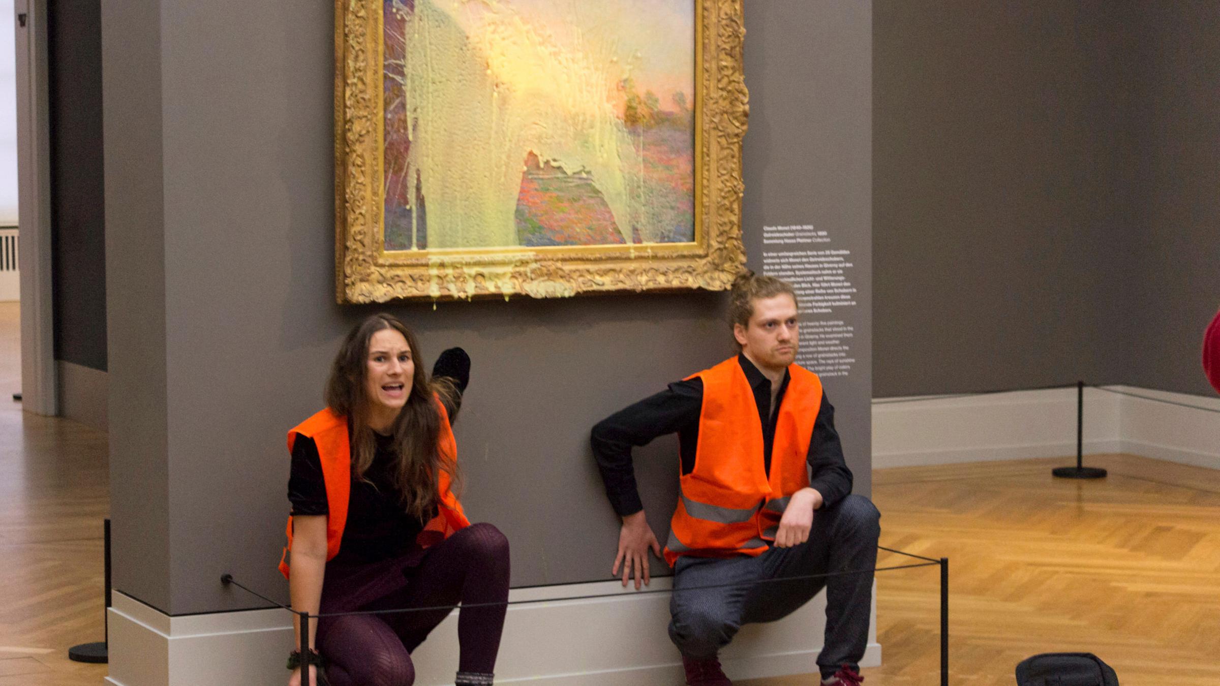 Zwei Aktivisten der Gruppe "Die Letzte Generation" haben ein Monet Bild im Museum Barberini mit Kartoffelbrei beworfen und sich darunter mit den Händen an die Wank geklebt.