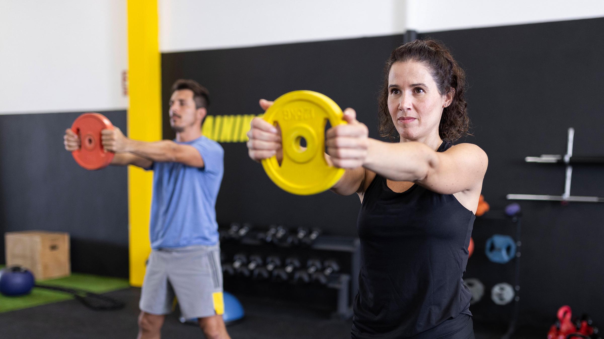 Eine Frau und ein Mann trainieren im Fitnessstudio