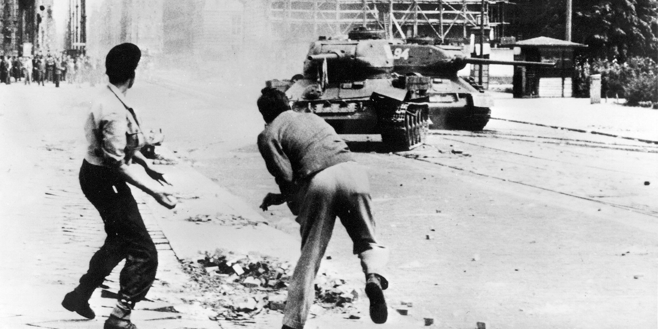 Demonstranten werden Steine auf einen russischen Panzer in Ost-Berlin