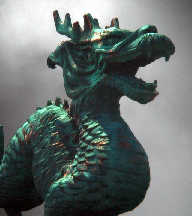 Montage: Eine Drachenfigur steht vor einem nebligen Hintergrund, daneben ist eine alte Weltkarte angedeutet.