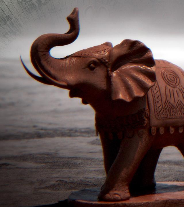 Montage: Eine Elefantenstatue steht auf einer Landkarte, daneben ist eine alte Weltkarte angedeutet.