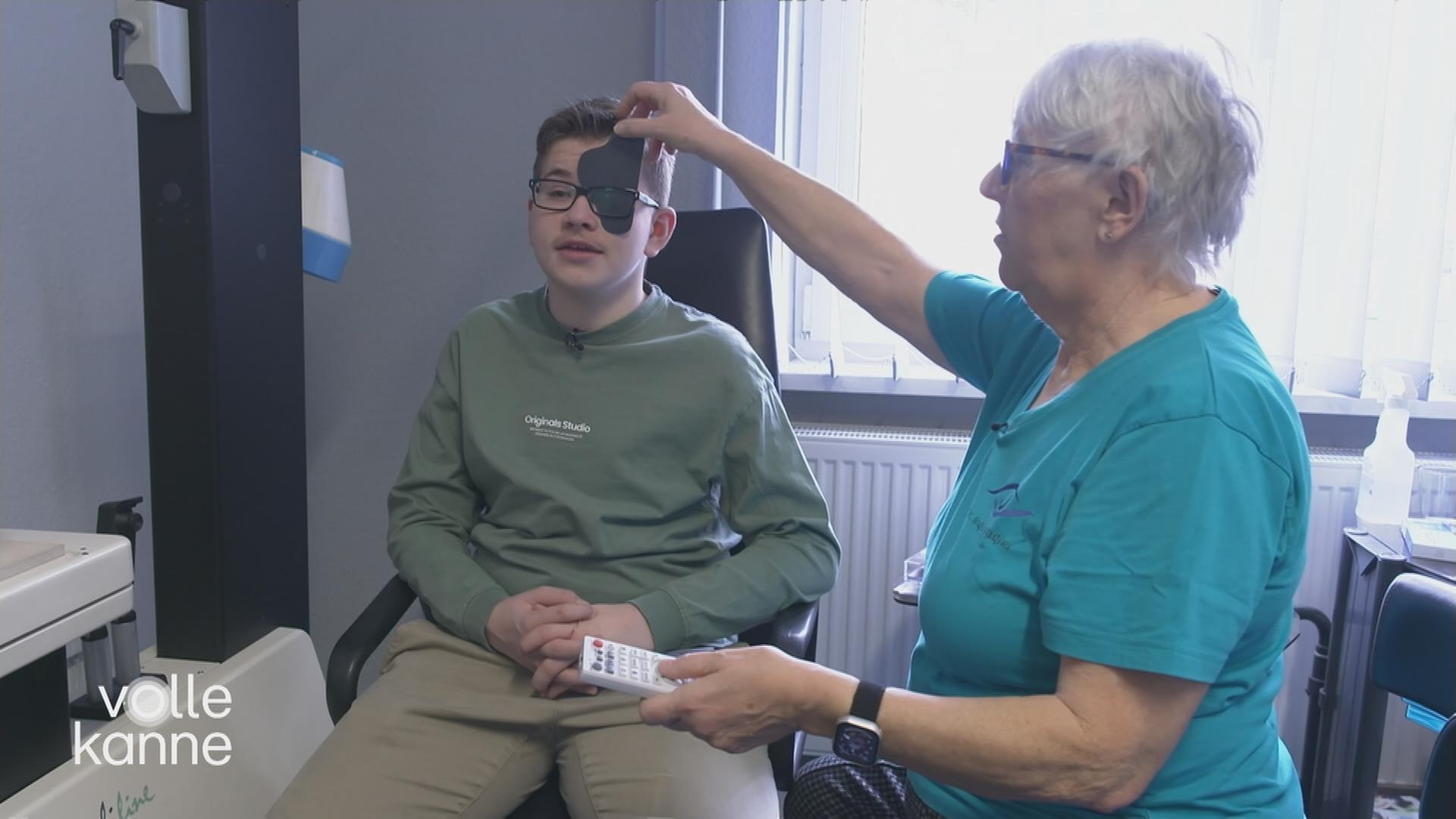 Ein Junge sitzt beim Augenarzt auf einem Stuhl.