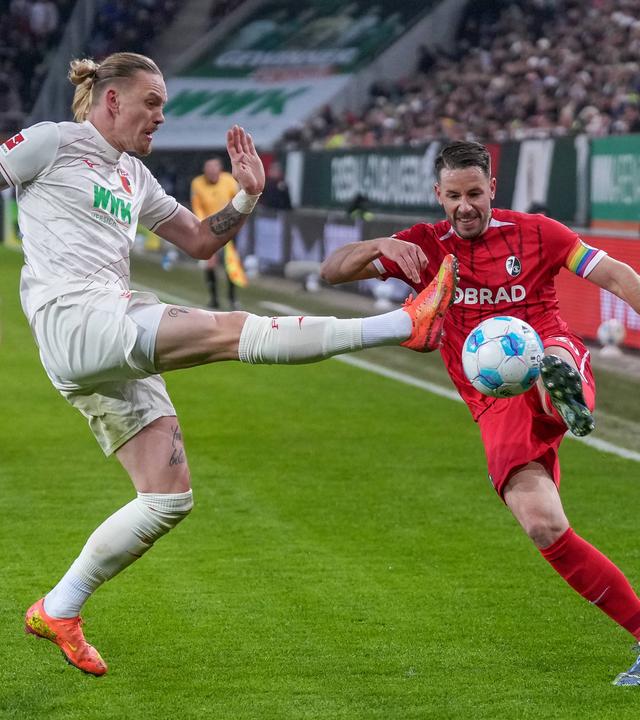 Augsburgs Marius Wolf und Freiburgs Christian Günther im Kampf um den Ball beim Spiel am 02.03.2025.