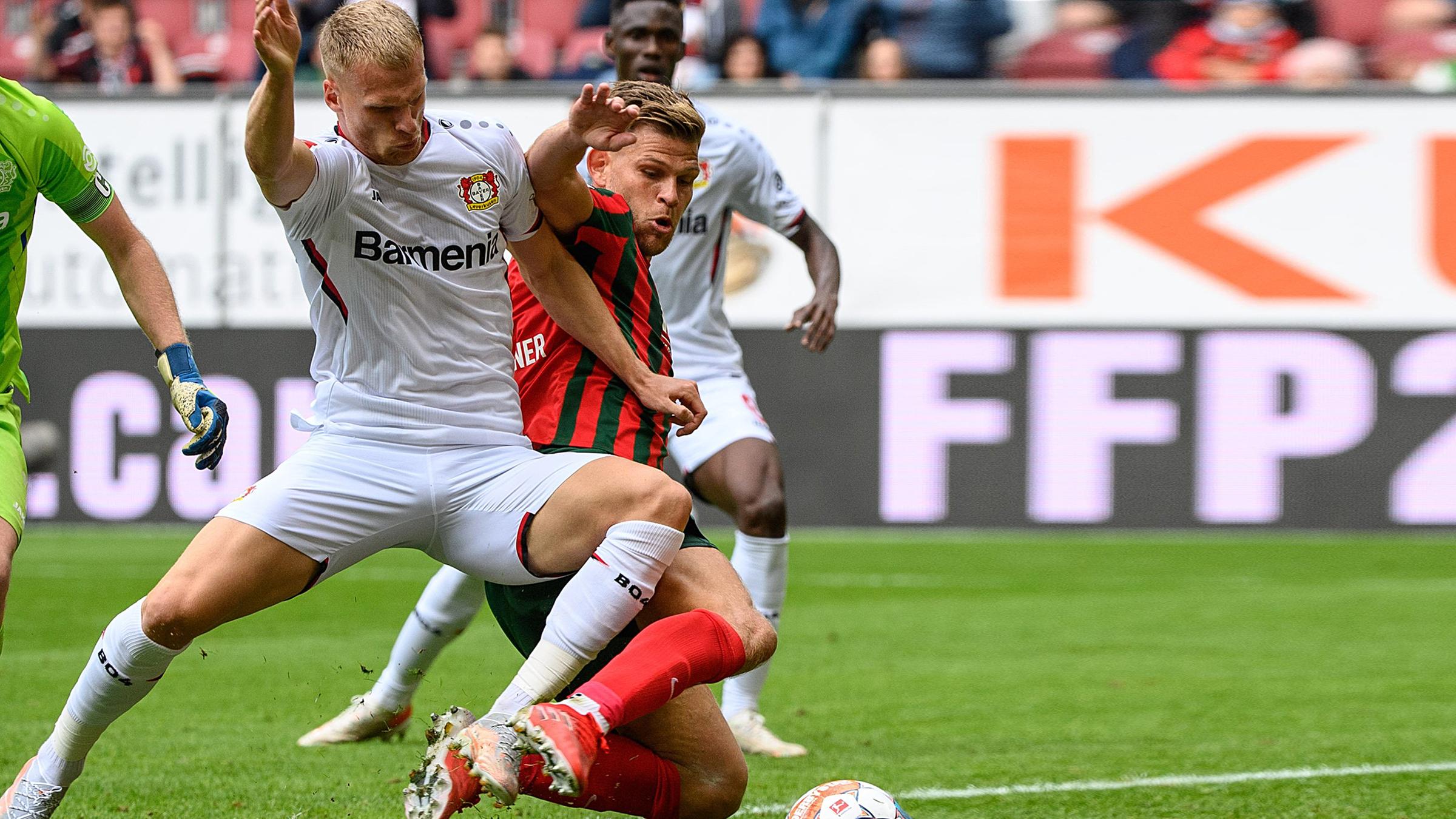 28.08.2021, Bayern, Augsburg: Fußball: Bundesliga, FC Augsburg - Bayer Leverkusen, 3. Spieltag, WWK-Arena. Florian Niederlechner von Augsburg (r) setzt sich im Zweikampf gegen Mitchel Bakker von Leverkusen durch und trifft zum 1:2.