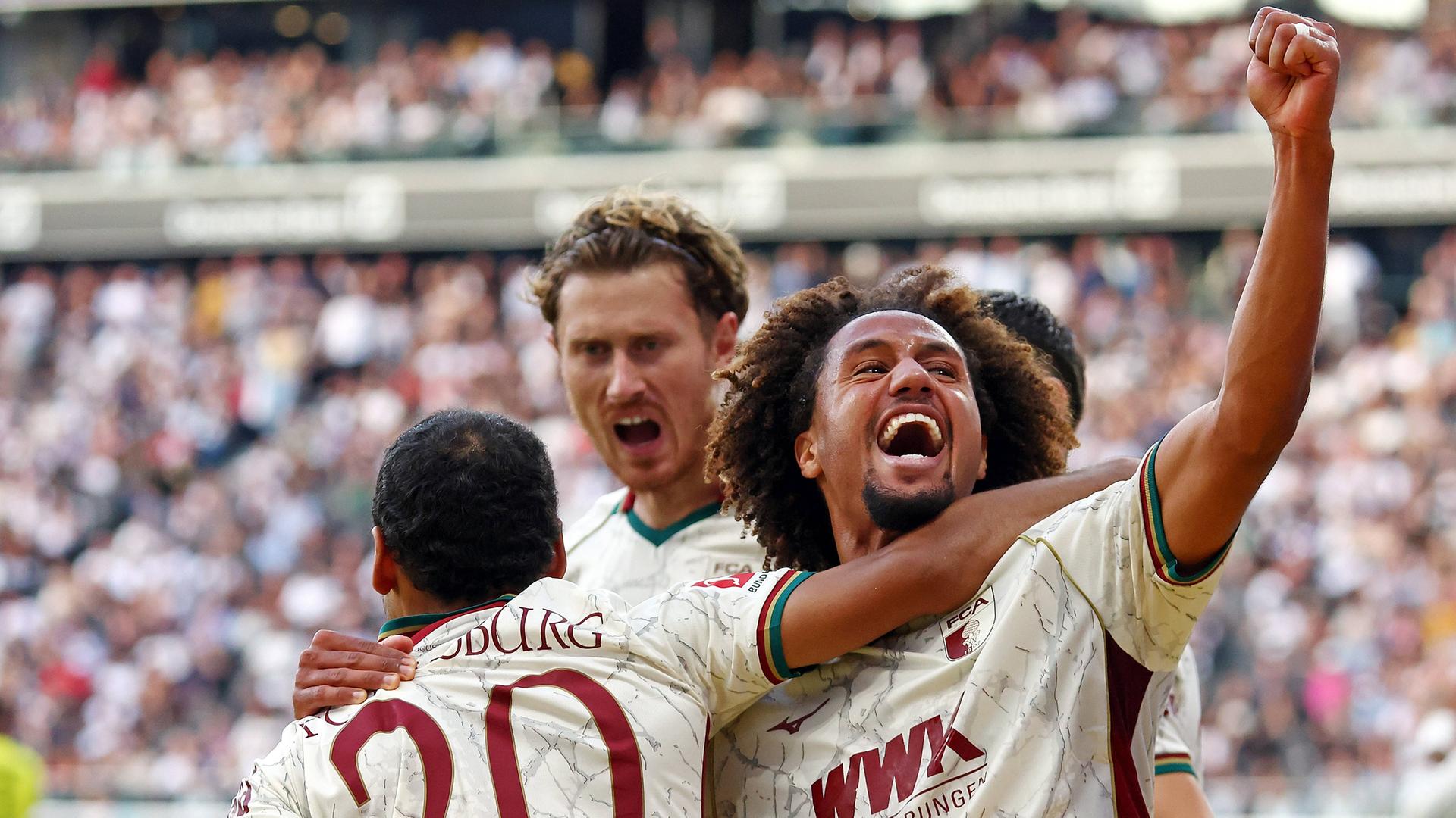 Alexis Claude-Maurice, Michael Gregoritsch und Han-Noah Massengo vom FC Augsburg bejubeln den Treffer zum 1:3 in der Bundesligapartie gegen Eintracht Frankfurt