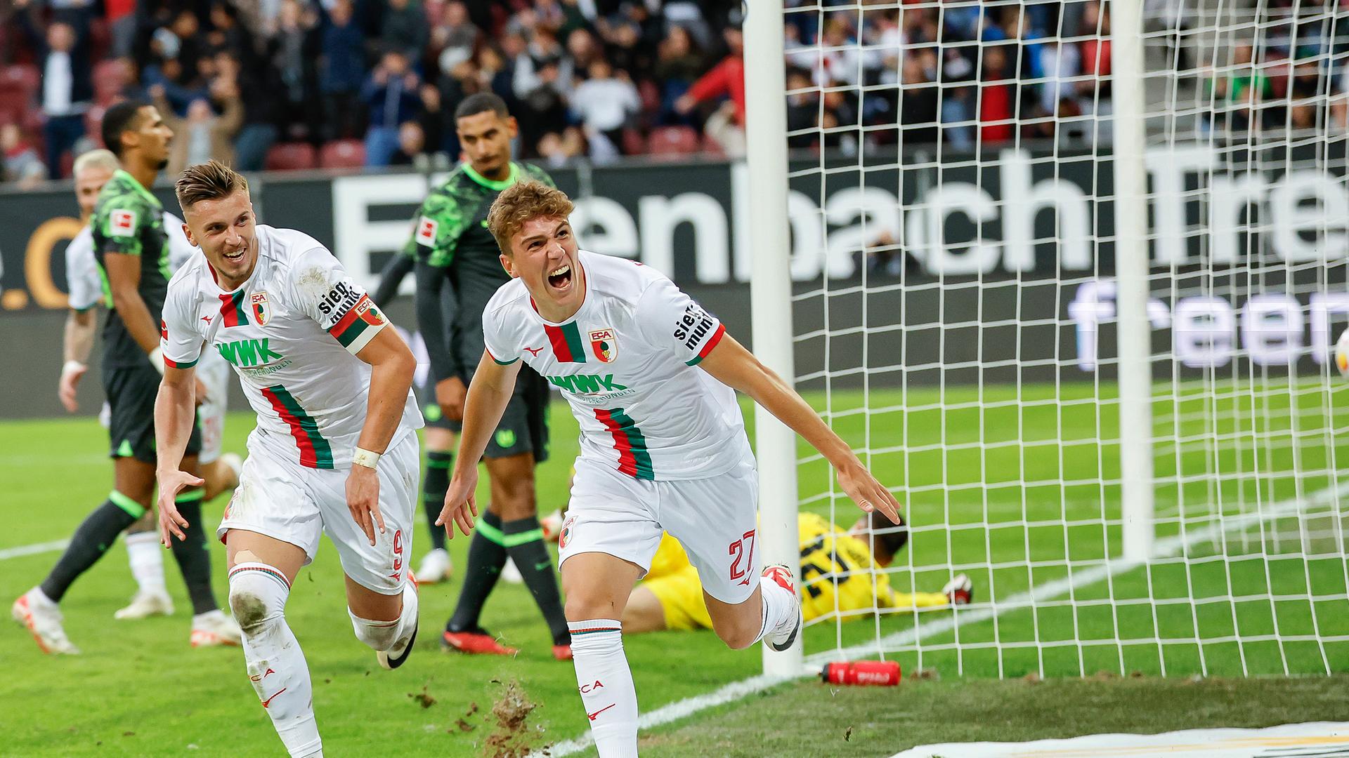 Der Augsburger Torschütze Arne Engels (r) jubelt mit Kapitän Ermedin Demirovic nach seinem Tor zum 3:2 am 28.10.23.