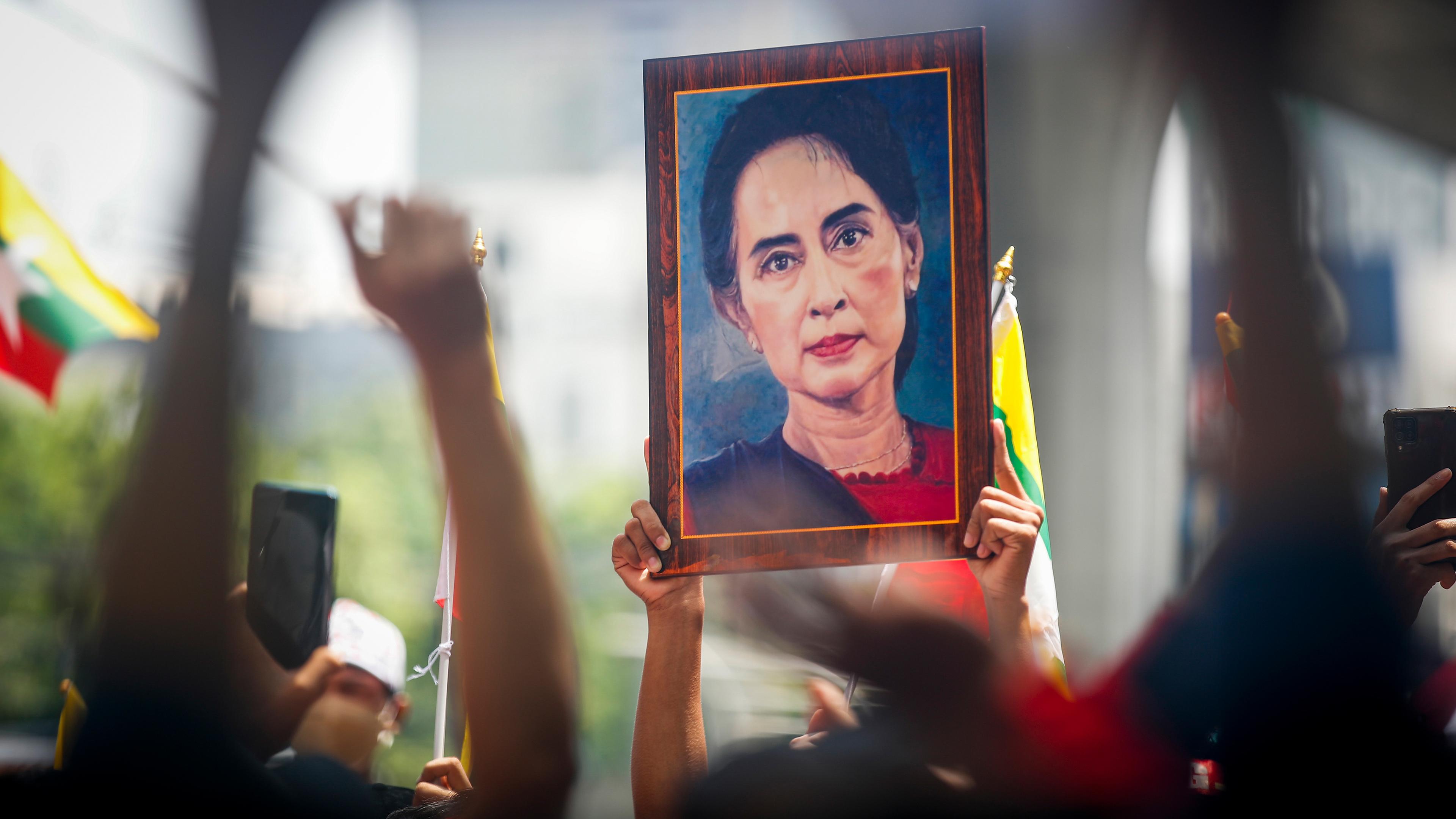 Myanmarische Staatsangehörige halten ein großes Bild von Aung San Suu Kyi während einer Kundgebung hoch, aufgenommen am 26.07.2022 in Bangkok