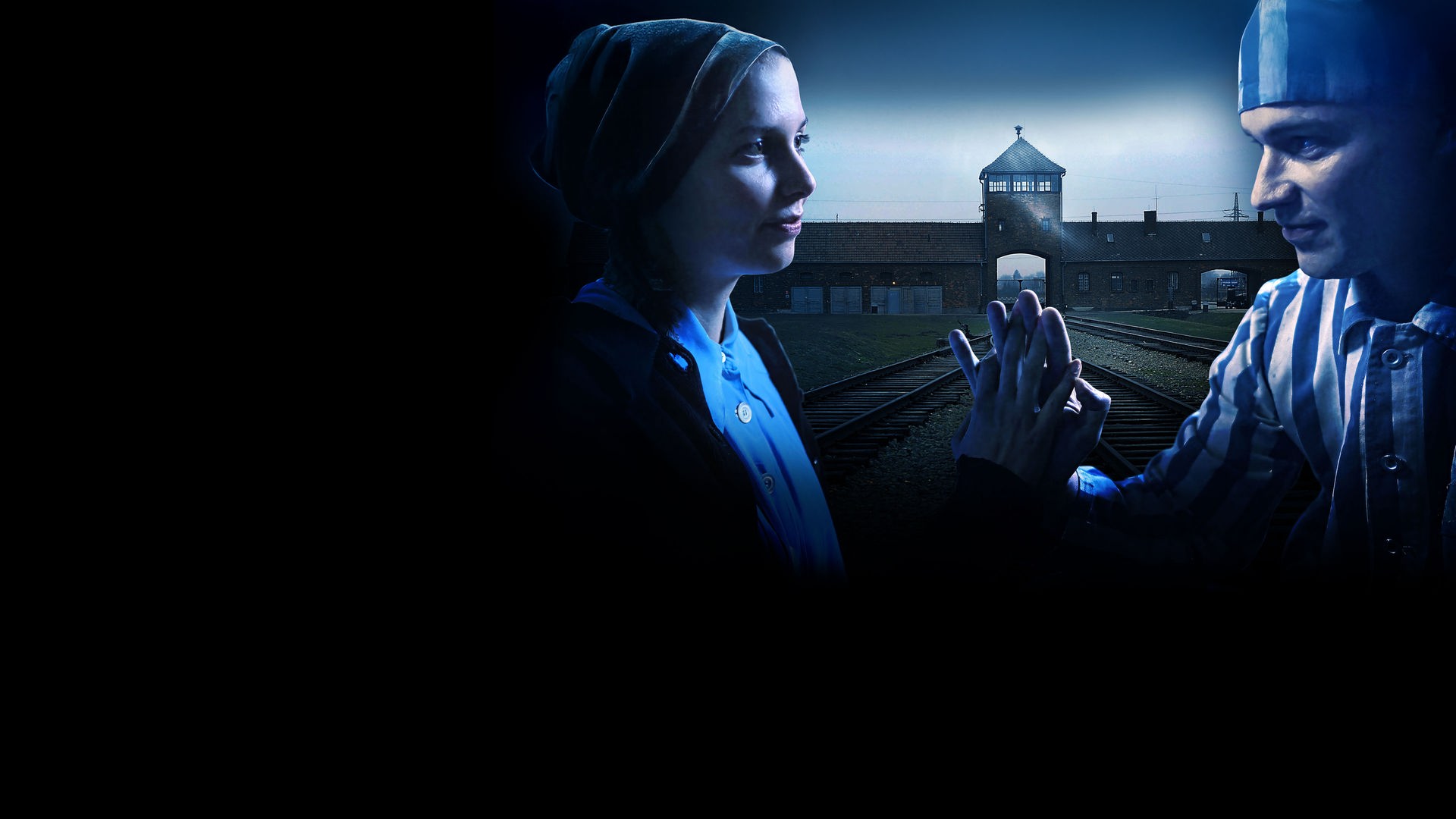 Im Vordergrund ein Liebespaar, das sich gegenüber sitzt und die Hände in Verbundeheit gegeneinander hält. Dahinter die Einfahrt zum KZ Ausschwitz