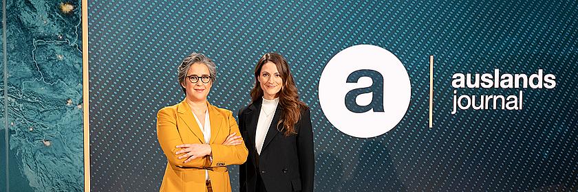 Die Moderatorinnen des ZDF-"auslandsjournal": Shakuntala Banerjee und Alica Jung stehen neben dem Sendelogo