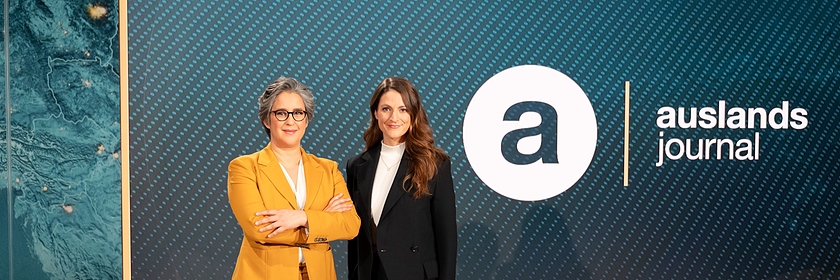 Die Moderatorinnen des ZDF-"auslandsjournal": Shakuntala Banerjee und Alica Jung stehen neben dem Sendelogo