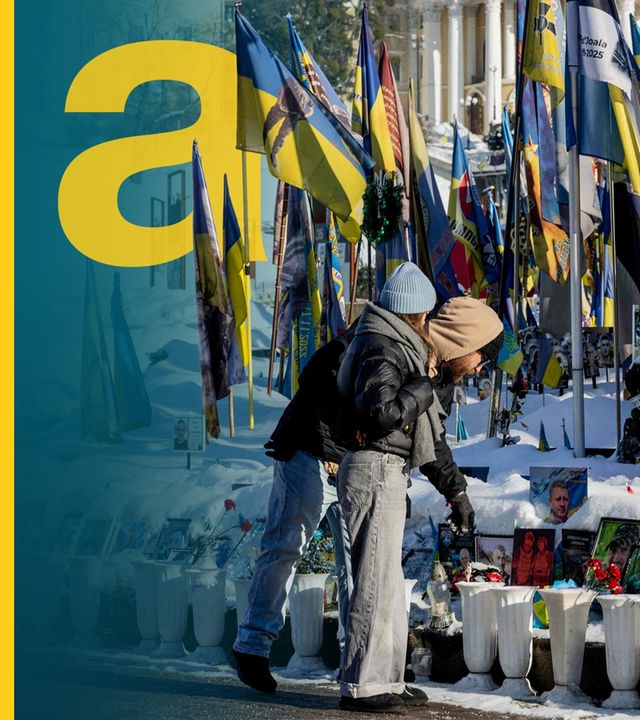 Menschen legen Blumen am Majdan Nesaleschnosti in Kiyv nieder. 