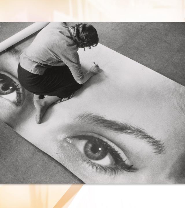 Man sieht eine Schwarz-Weiß-Fotografie, auf der eine Frau am Boden sitzt und an einem Kunstwerk arbeitet.