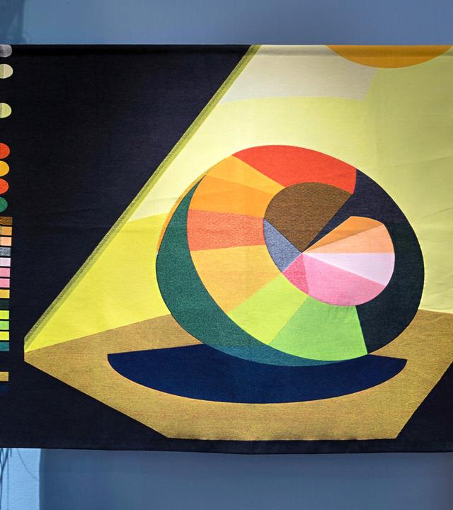 Man sieht die Installation eines modernen, bunten Kunstwerkes in einem Ausstellungsraum.