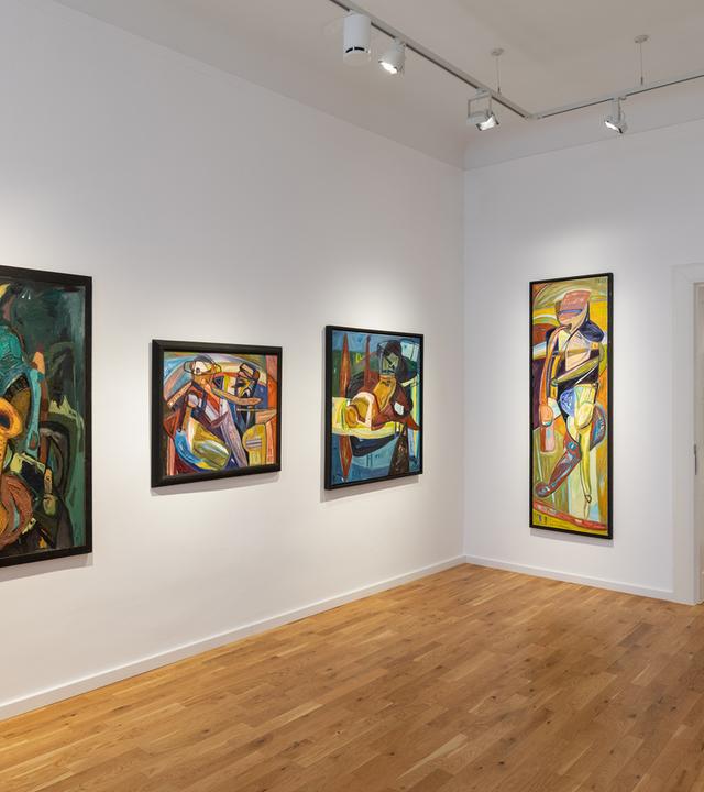 In einem Ausstellungsraum hängen moderne Gemälde an der Wand.