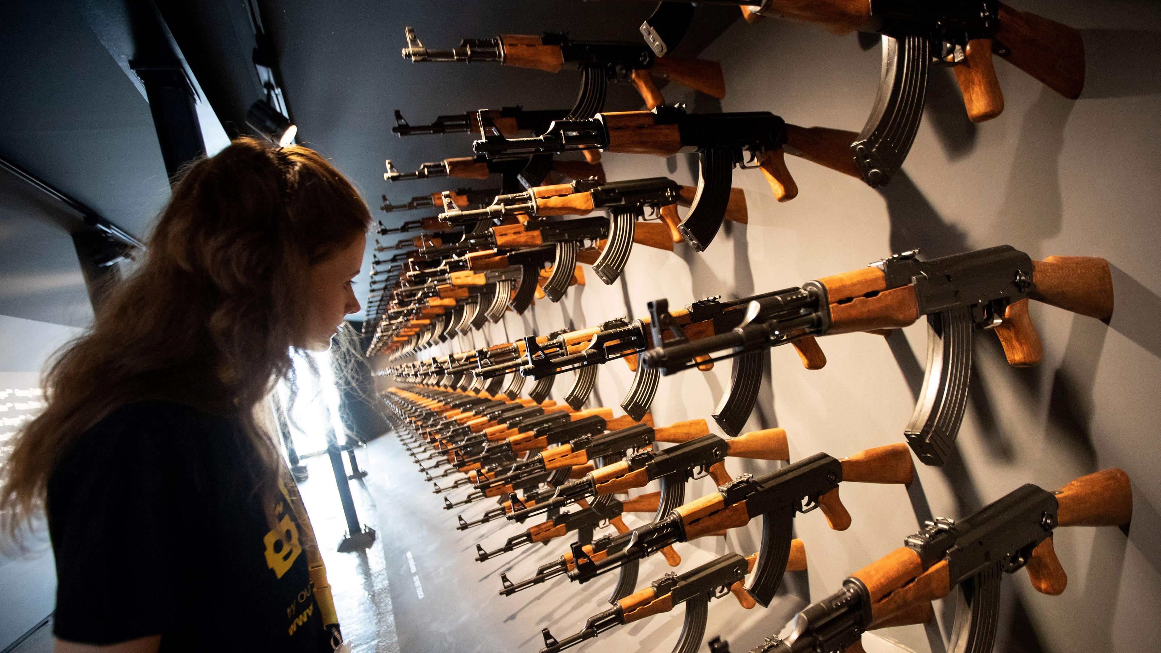 Eine Besucherin steht vor einer Installation aus 140 Kalashnikow-Gewehren