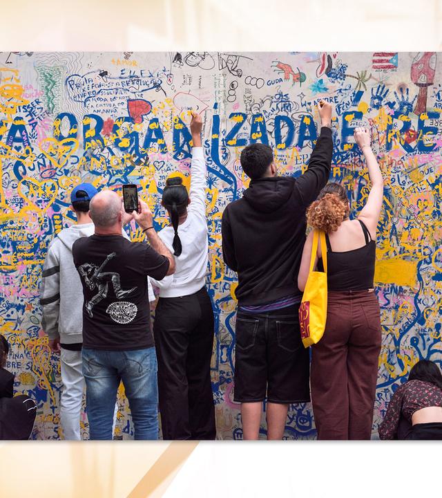 Man sieht wie mehrere Personen an einem Bild malen.