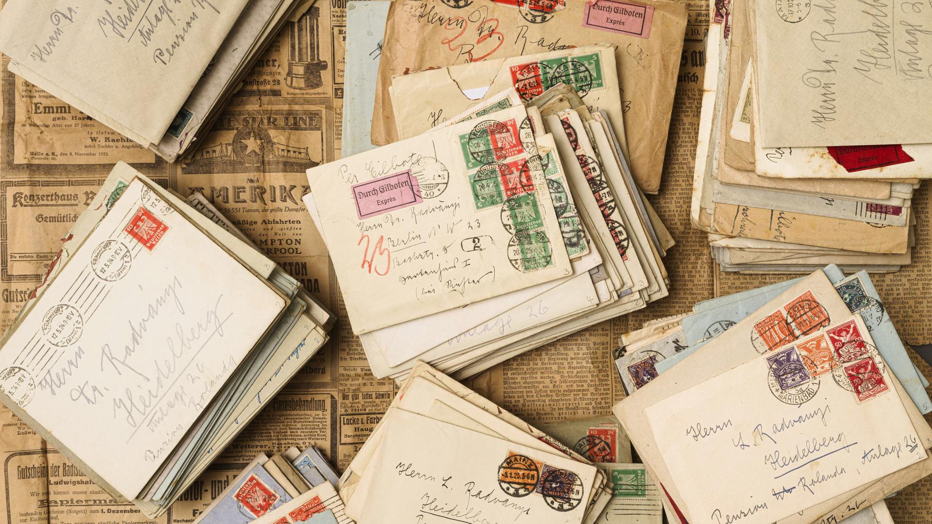 Auf historischen Zeitungen liegen historische Briefe.