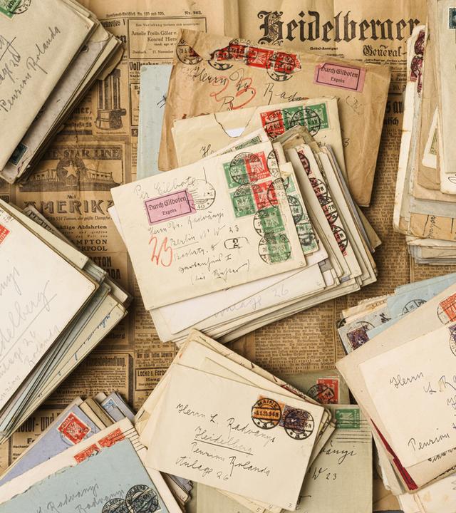 Auf historischen Zeitungen liegen historische Briefe.