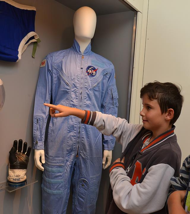 In einem Ausstellungsraum sehen sich zwei Kinder die Raumfahrtsexponate an.