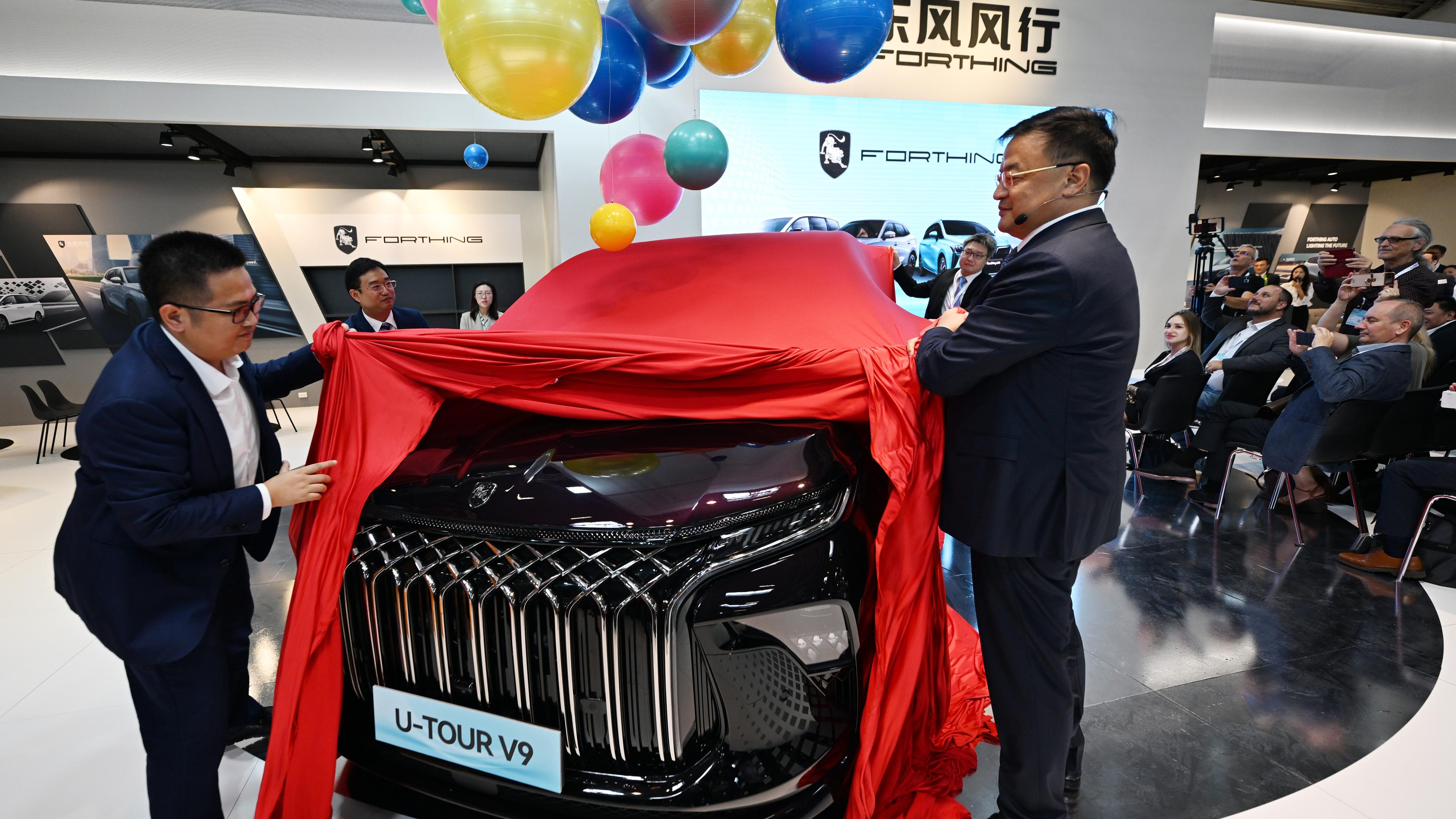 Bayern, München: Manager der Dongfeng Liuzhou Motor Co. Ltd. enthüllen ein neues Fahrzeug der Marke Forthing beim Pressetag der Auto- und Verkehrsmesse IAA in einer Halle der Messe München.