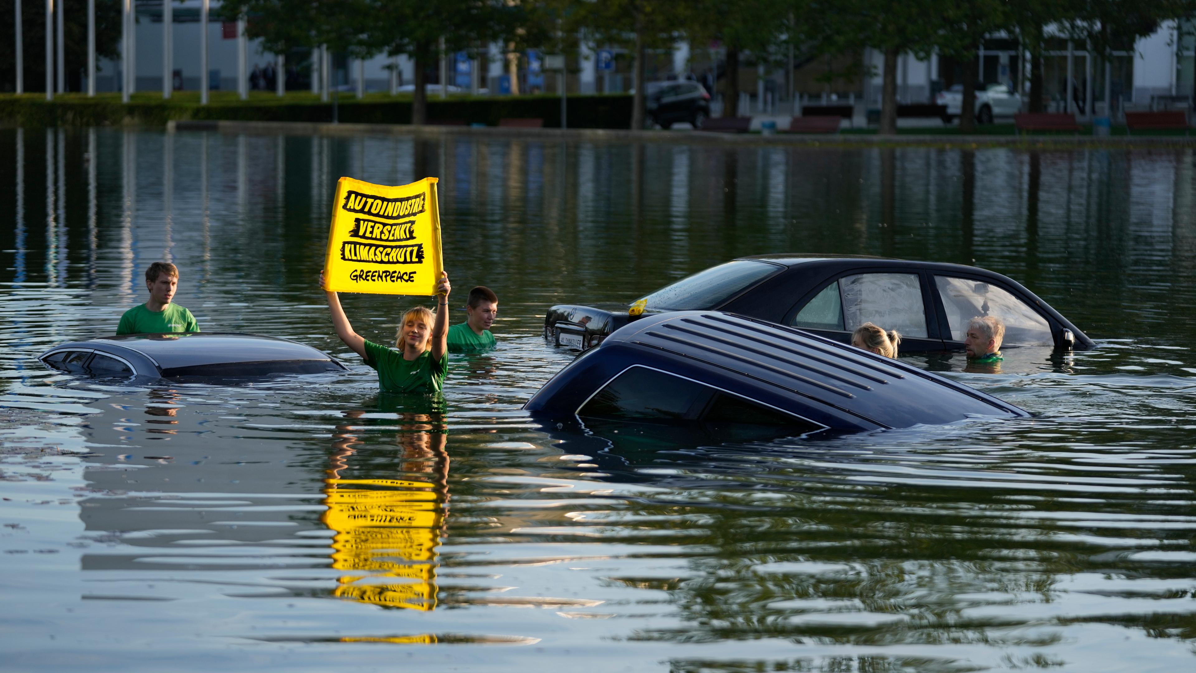 Greenpeace-Aktivisten versenken Autos im Wasser vor der Automesse IAA in München.