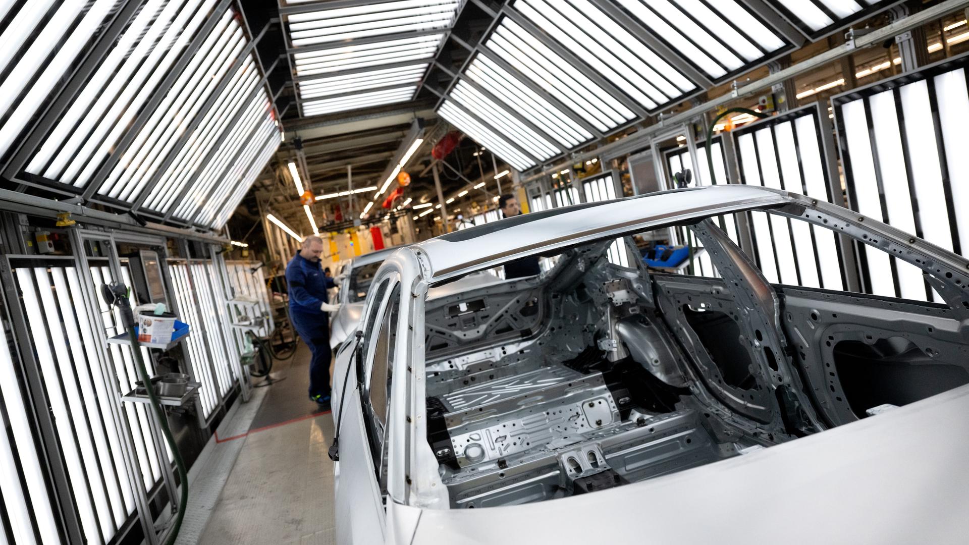 05.12.2023, Bayern, München: Mitarbeiter von BMW arbeiten im Stammwerk in der Produktion an der Karosserie von verschiedenen Modellen des Autoherstellers.