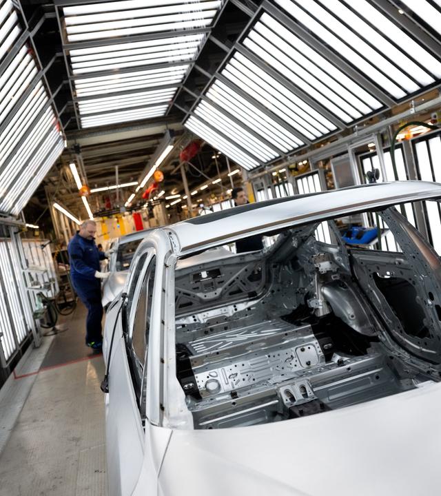 05.12.2023, Bayern, München: Mitarbeiter von BMW arbeiten im Stammwerk in der Produktion an der Karosserie von verschiedenen Modellen des Autoherstellers.