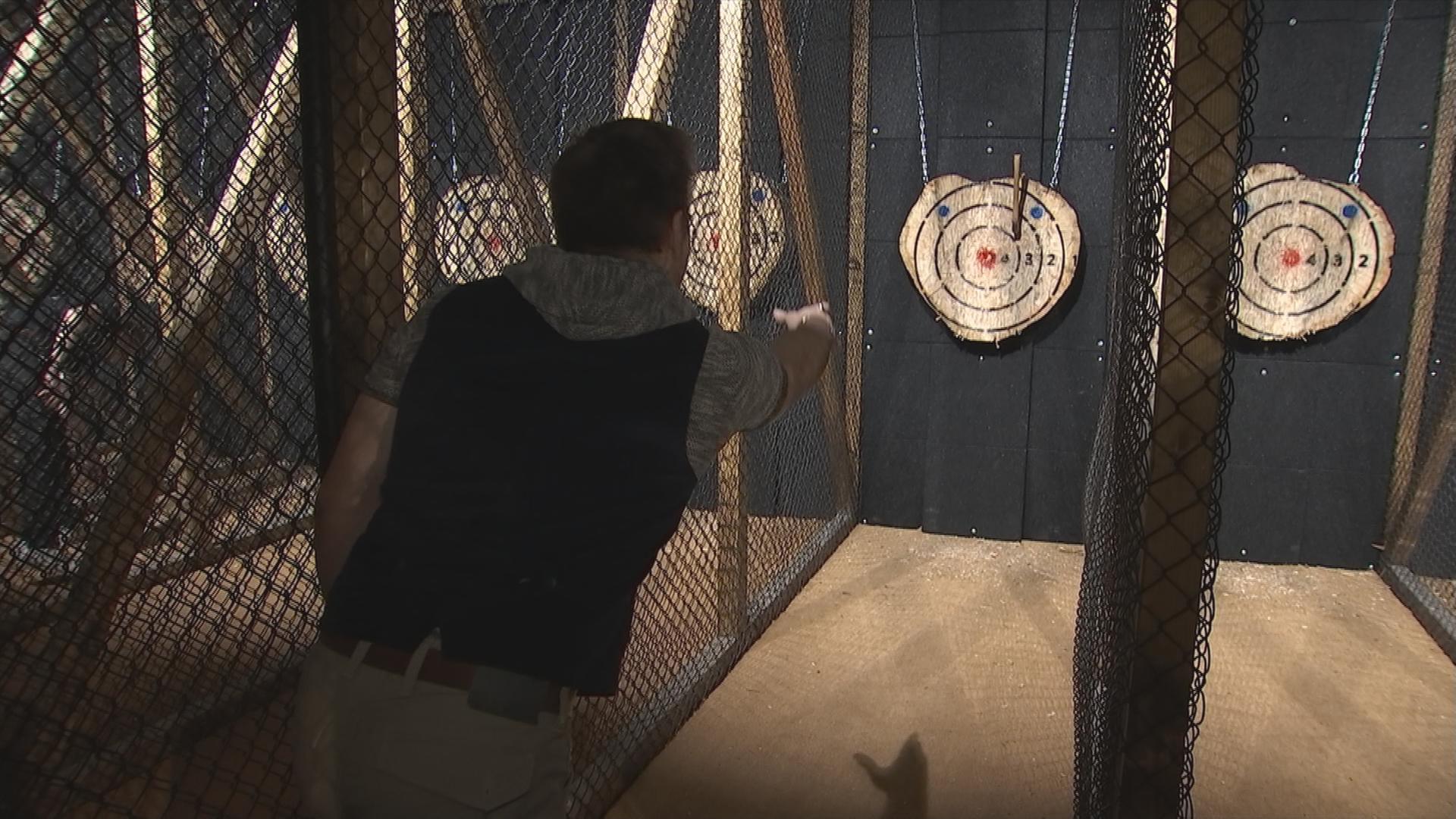 Auf dem Bild sieht man einen Man der in einer Hamburger Bar das Spiel Axr-Wurf spielt.