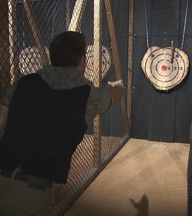 Auf dem Bild sieht man einen Man der in einer Hamburger Bar das Spiel Axr-Wurf spielt.