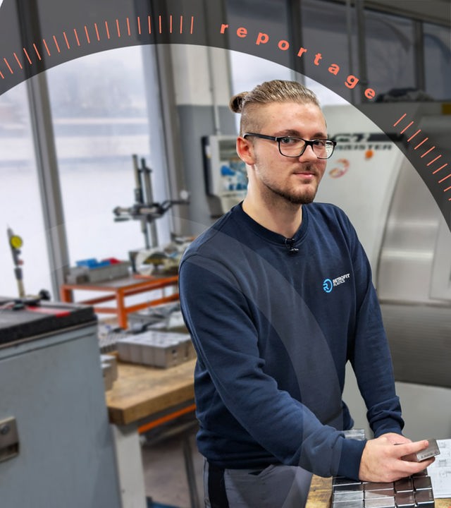 Ausbilder Markus Mittelsdorf und sein Lehrling Carlos stehen in einem Werkraum vor der CNC-Fräse.