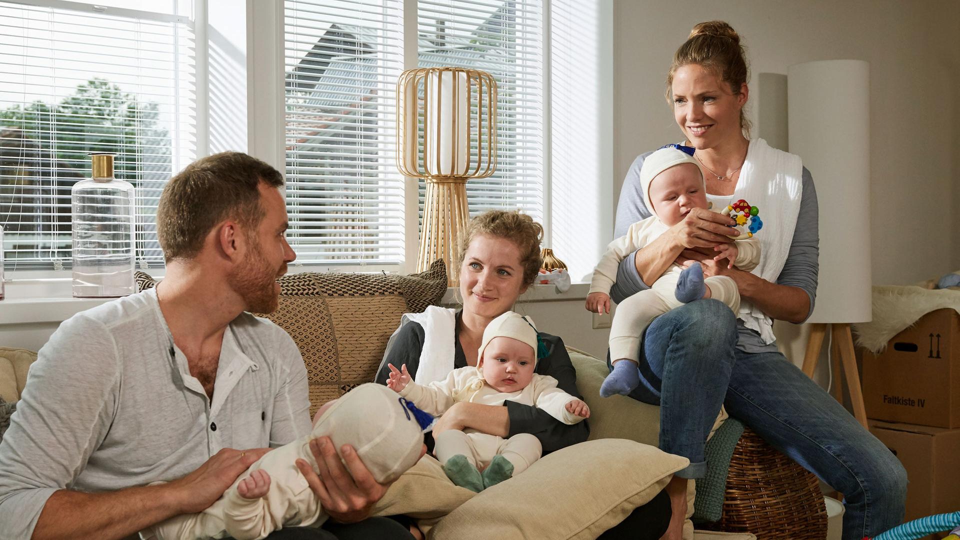 "Lena Lorenz - Babyglück hoch drei": Hebamme Lena Lorenz (Patricia Aulitzky) und die Eltern Emma (Cornelia Gröschel) und Karl Wagner (Bernhard Piesk) in deren Wohnzimmer. Alle drei halten jeweils ein Baby im Arm.