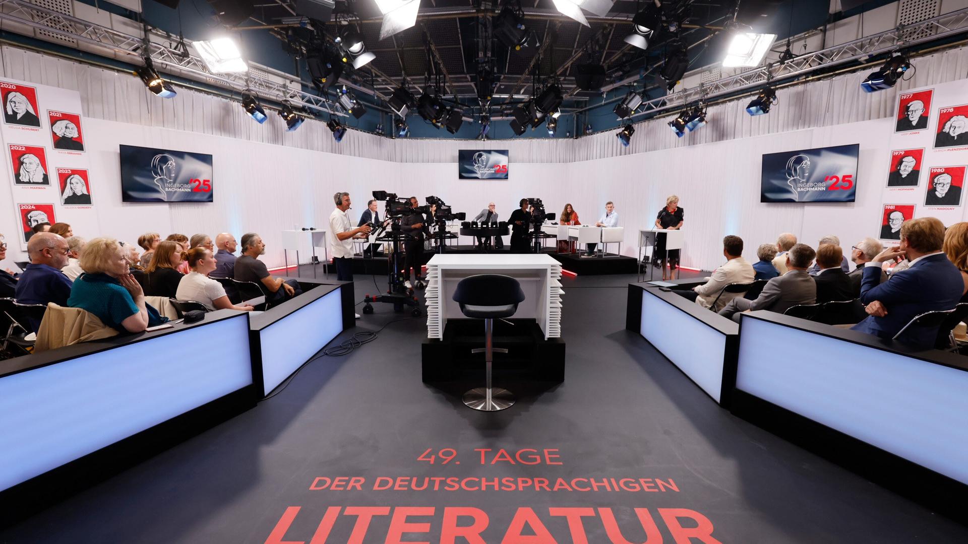 Blick ins ORF-Studio während einer Live-Sendung der Tage der deutschsprachigen Literatur  mit Jurytisch, Publikum, Kamerateam und Schriftzug 49. Tage der deutschsprachigen Literatur auf dem Boden.