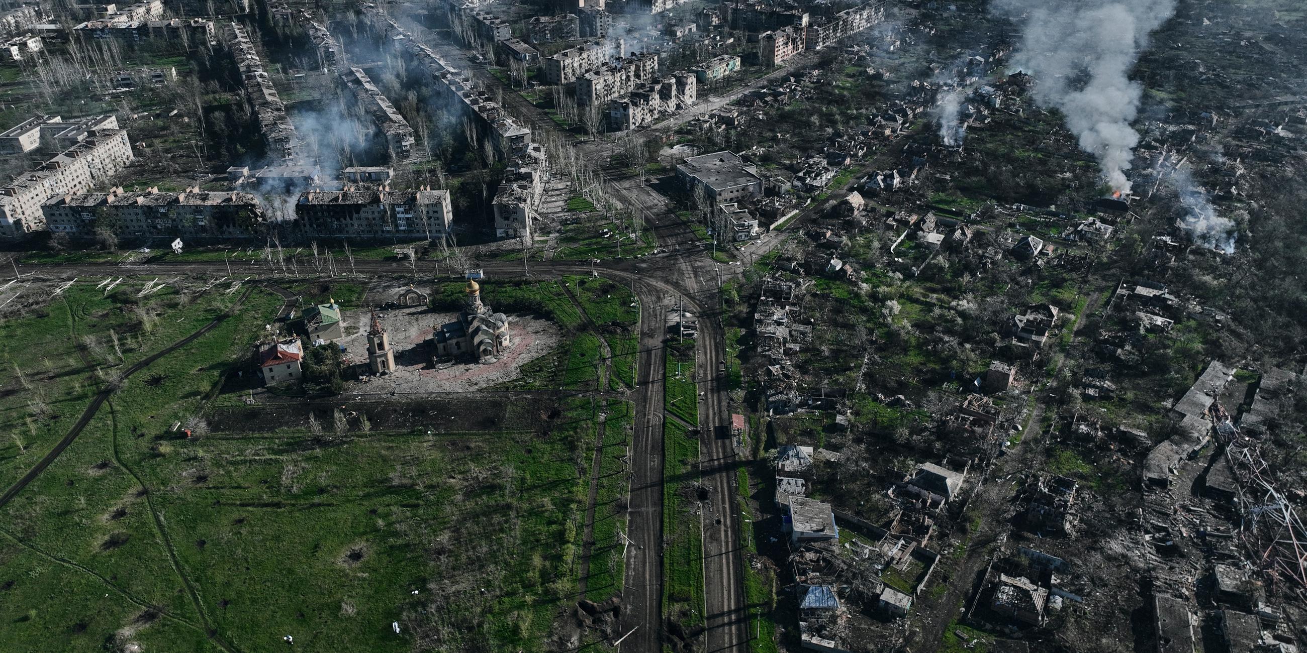 Luftaufnahme die zahlreiche zerstörte Gebäuden und Bombenkrater zeigt