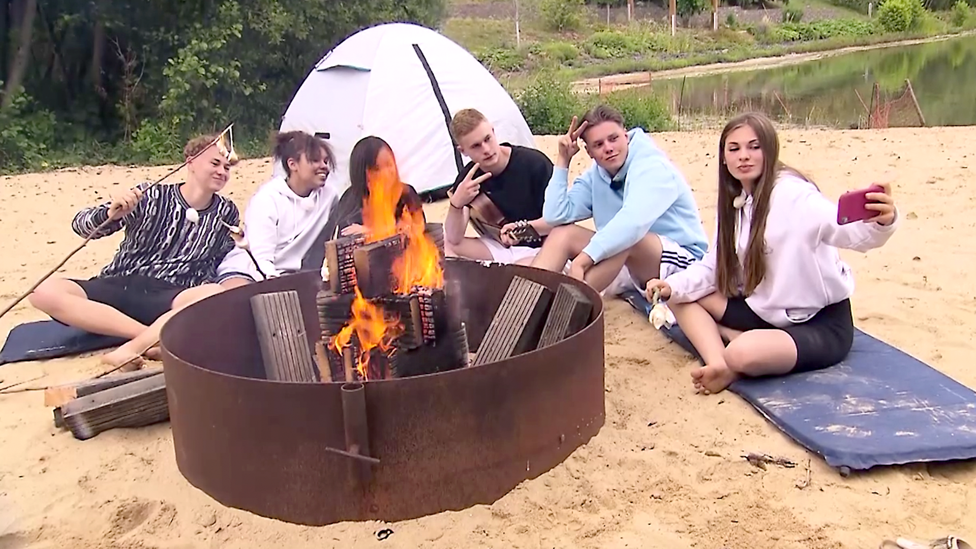 Angelina, Mark, Jeppe, Alex, Chantal und Trang sitzen am Lagerfeuer