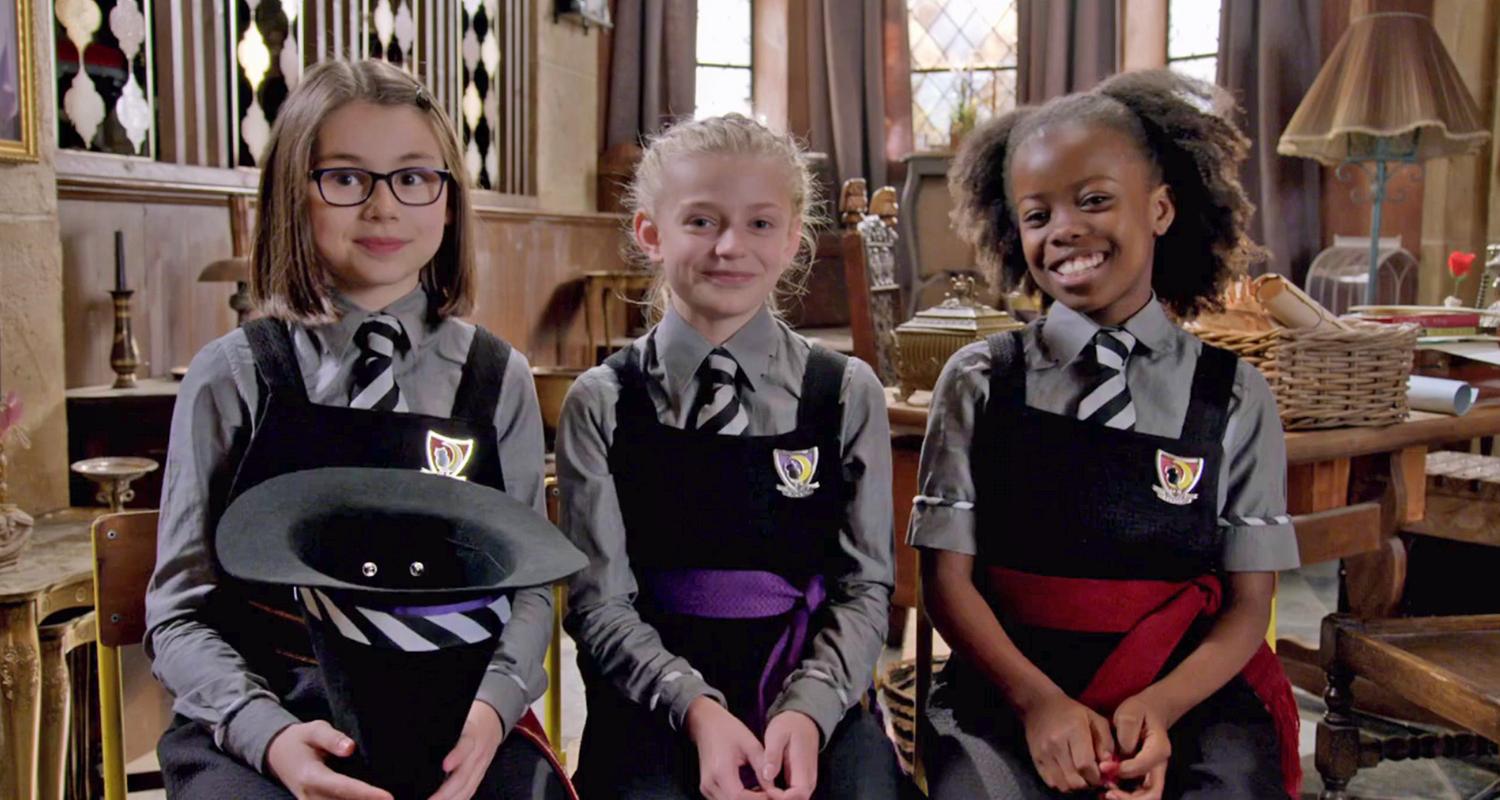 Kitty (links, spielt Clarissa), Trixie (Mitte, spielt Sybille) und Ynez (rechts, spielt Beatrix) sitzen in ihren Kostümen nebeneinander und lachen in die Kamera