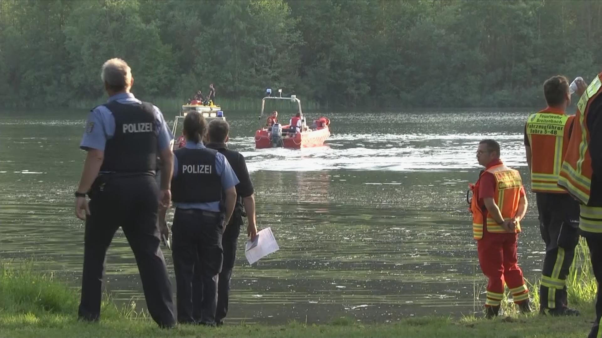 Rettungskräfte suchen am See nach den Vermissten.
