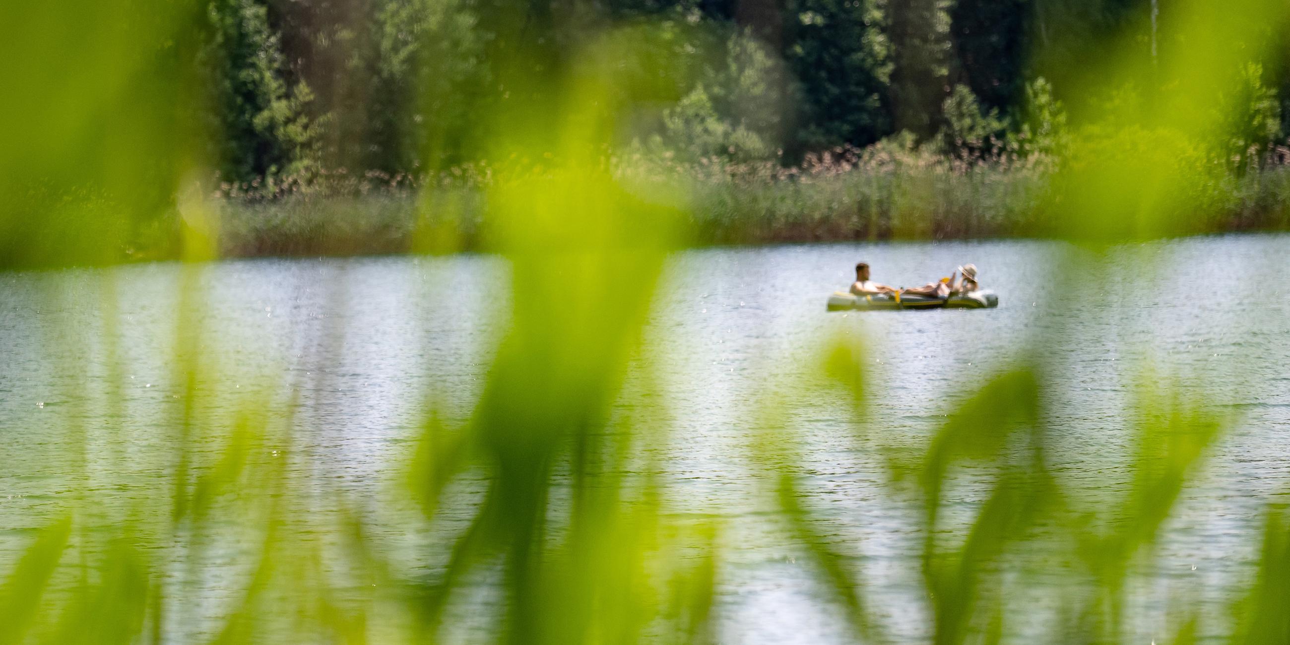 Zwei Personen sitzen bei sonnigem Wetter in einem Schlauchboot auf dem Großdöllner See. (10.06.2023)