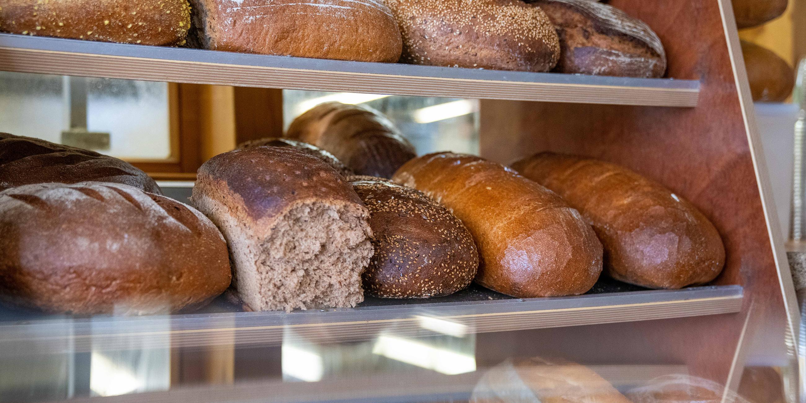 Frische Brote liegen in der Brottheke im Verkaufsraum einer Bäckerei