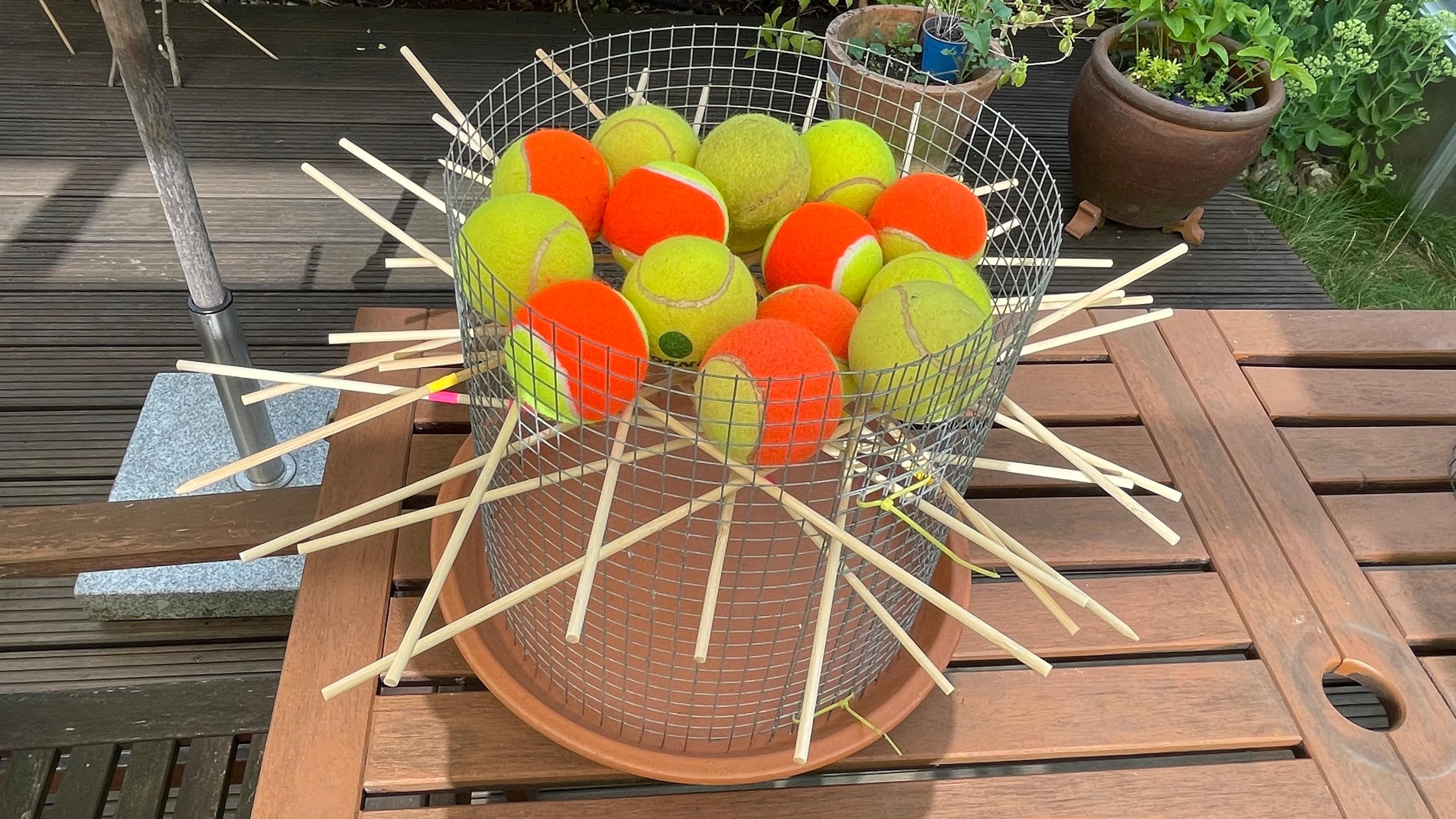 Mit Tennisbällen, einem Drahtgitter und Pflanzstäben lässt sich ein Bälle-Mikado bauen.