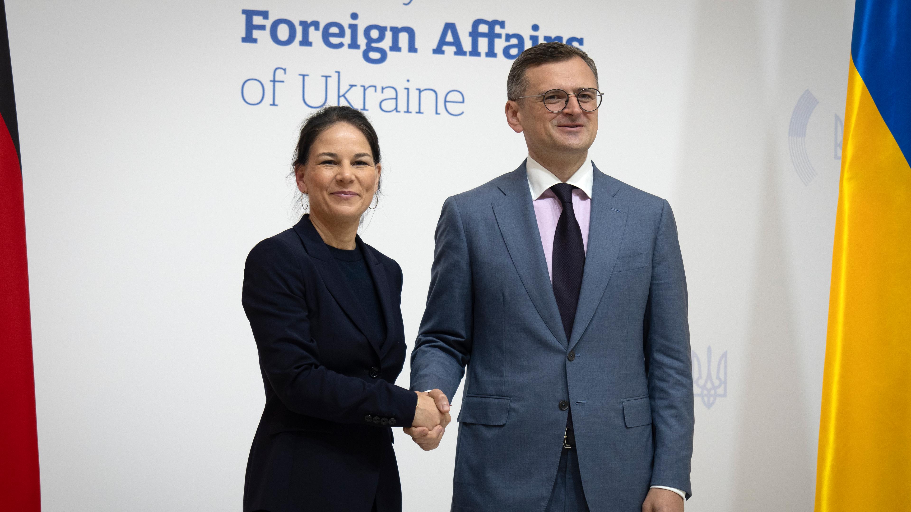 21.05.2024: Die deutsche Außenministerin Annalena Baerbock und der ukrainische Außenminister Dmytro Kuleba schütteln sich während ihres Treffens in Kiew die Hände.