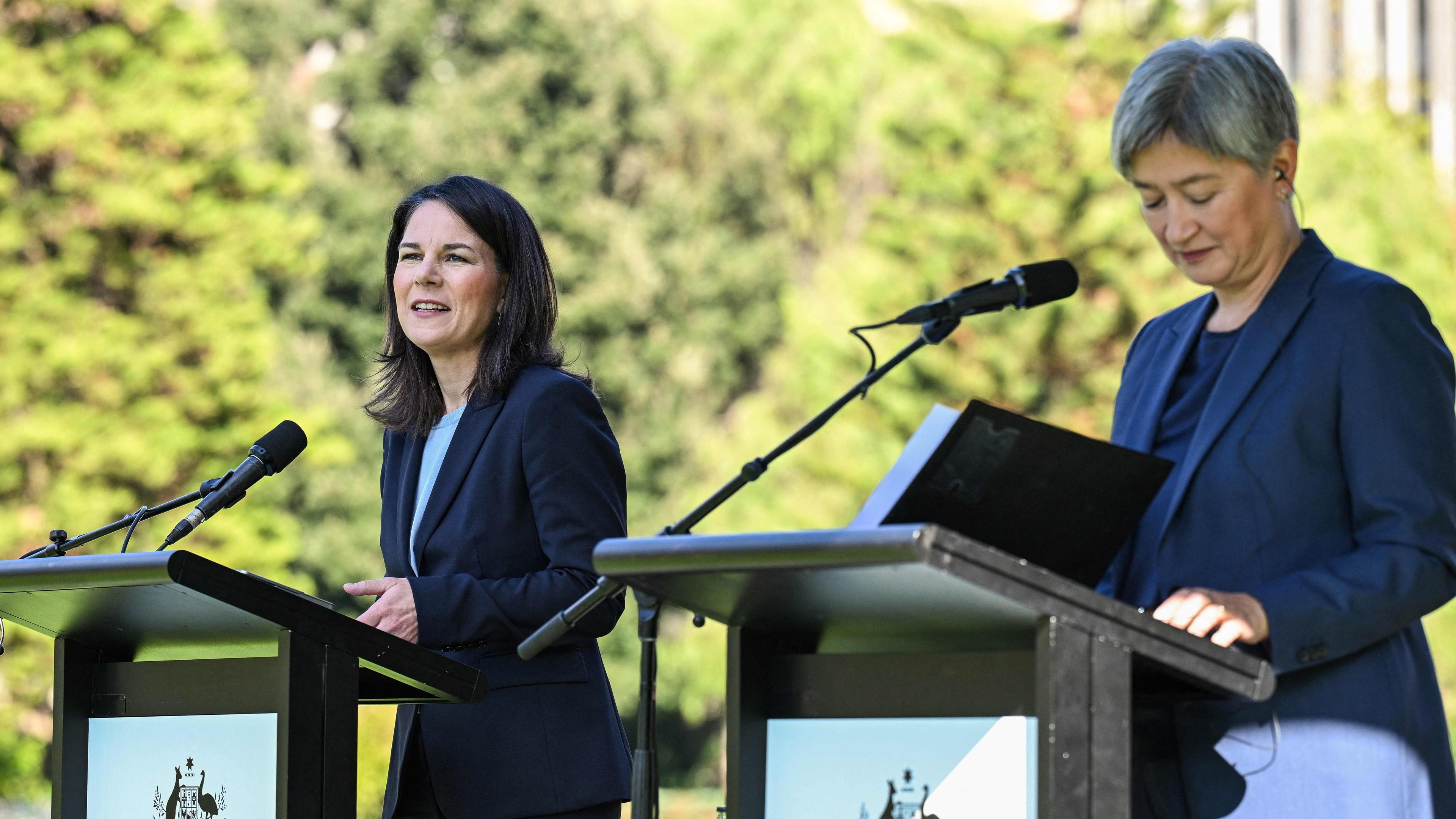 Außenministerin Baerbock und Wong halten eine Rede nebeneinander in Australien.