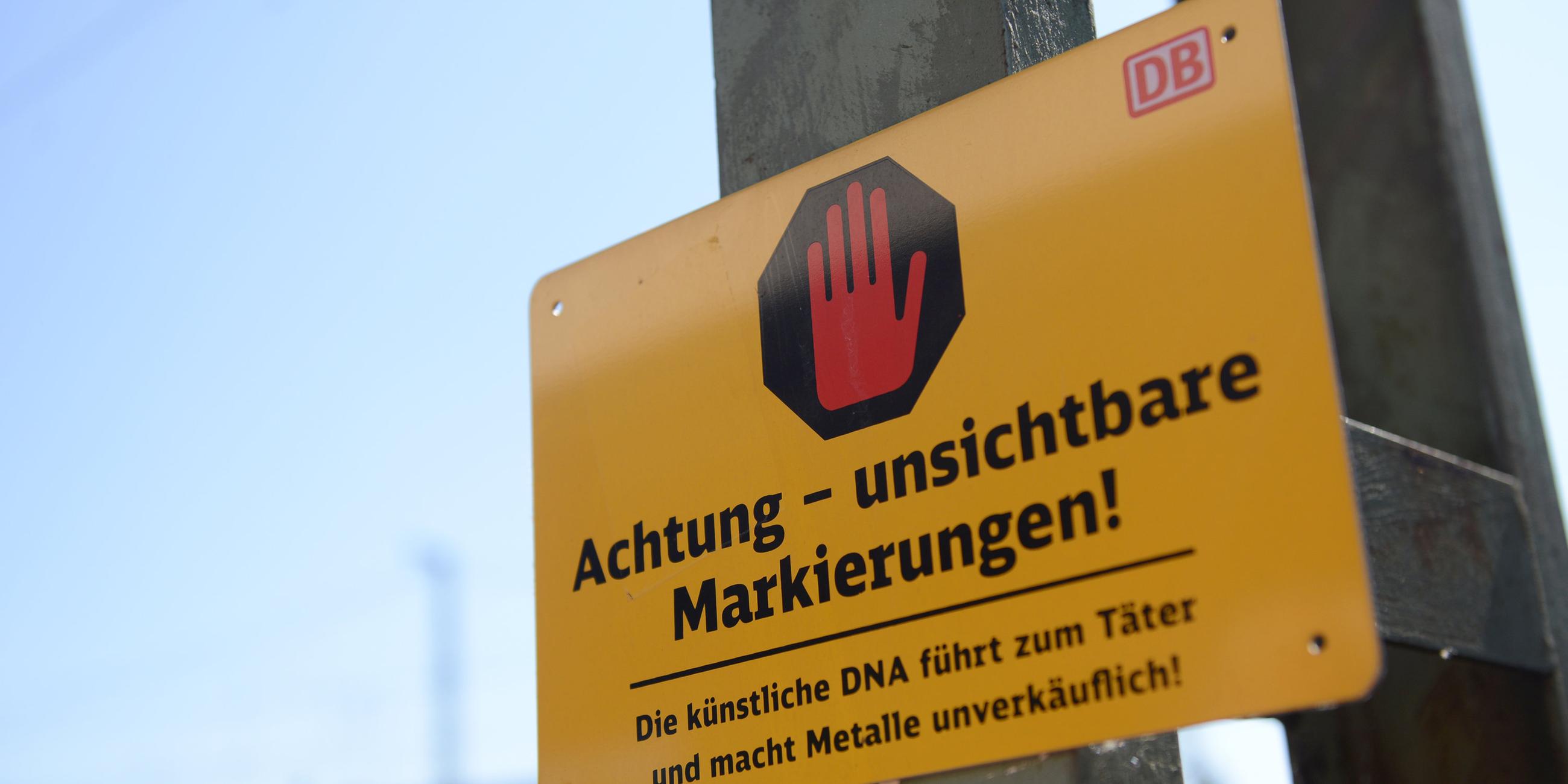 Ein Schild der Deutschen Bahn informiert am 19.07.2013 in Düsseldorf (Nordrhein-Westfalen) über die DNA Markierung auf den Leitungen.