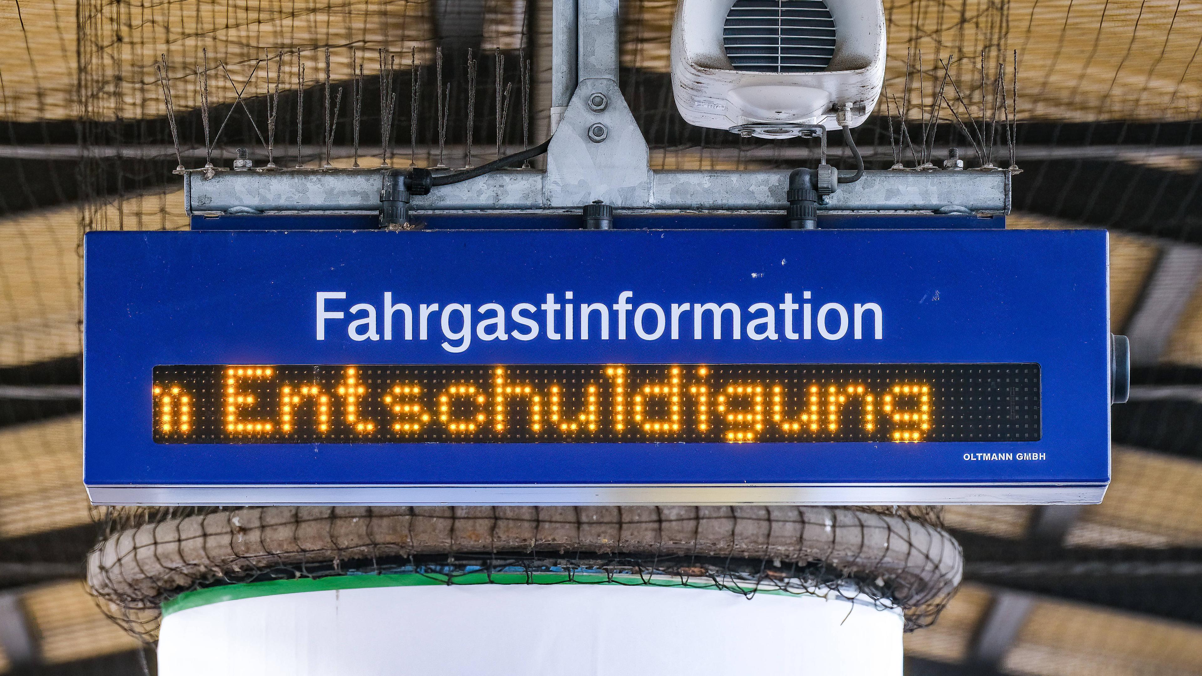 Am Düsseldorfer Bahnhof läuft am Bahnsteig die Fahrgastinformation "Entschuldigung" wegen einer Verspätung