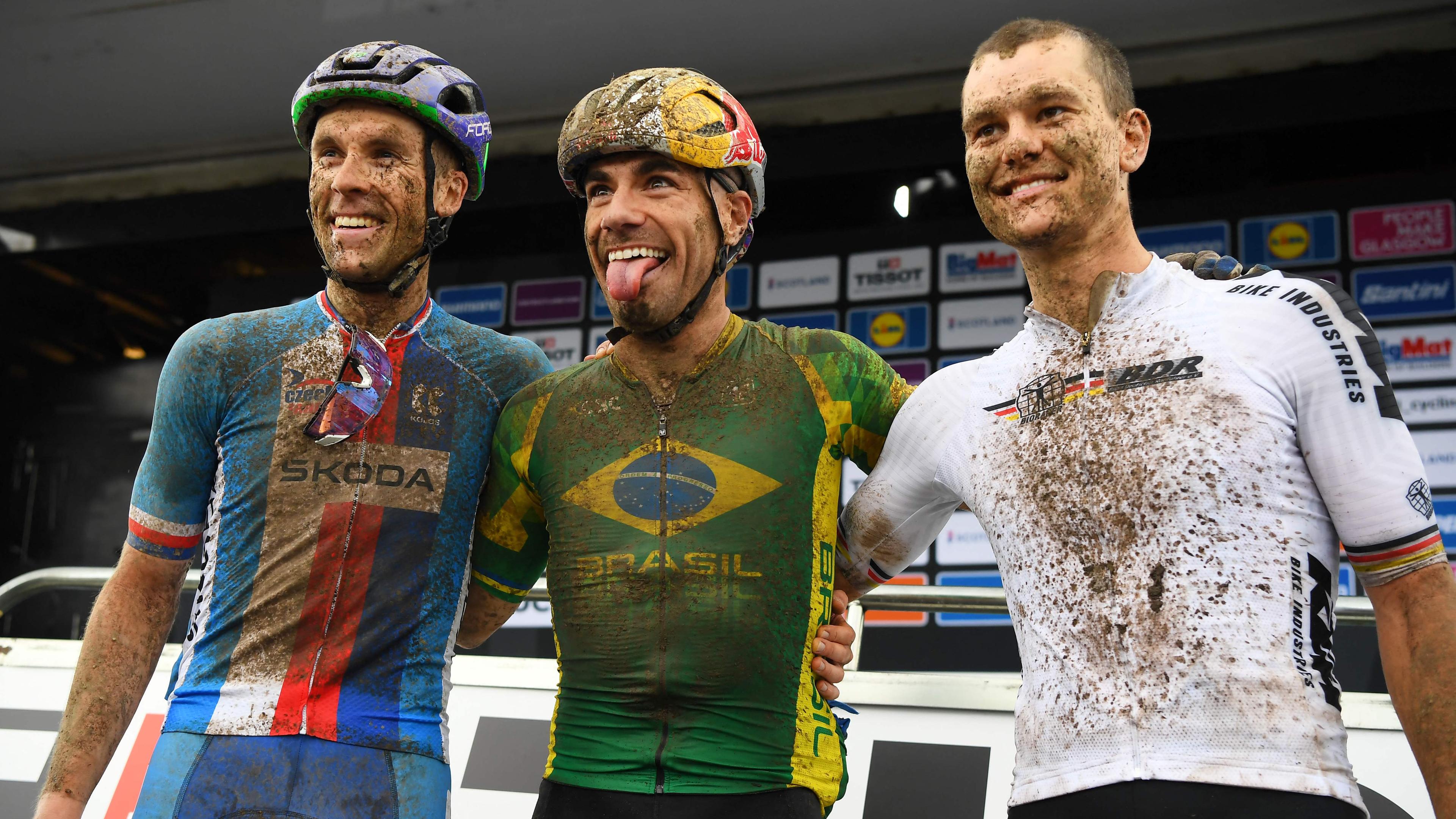 Martin Stosek, Henrique da Silva, Lukas Baum (von links) lachen im Ziel des Mountainbike-Marathons bei der WM 2023 in Glasgow
