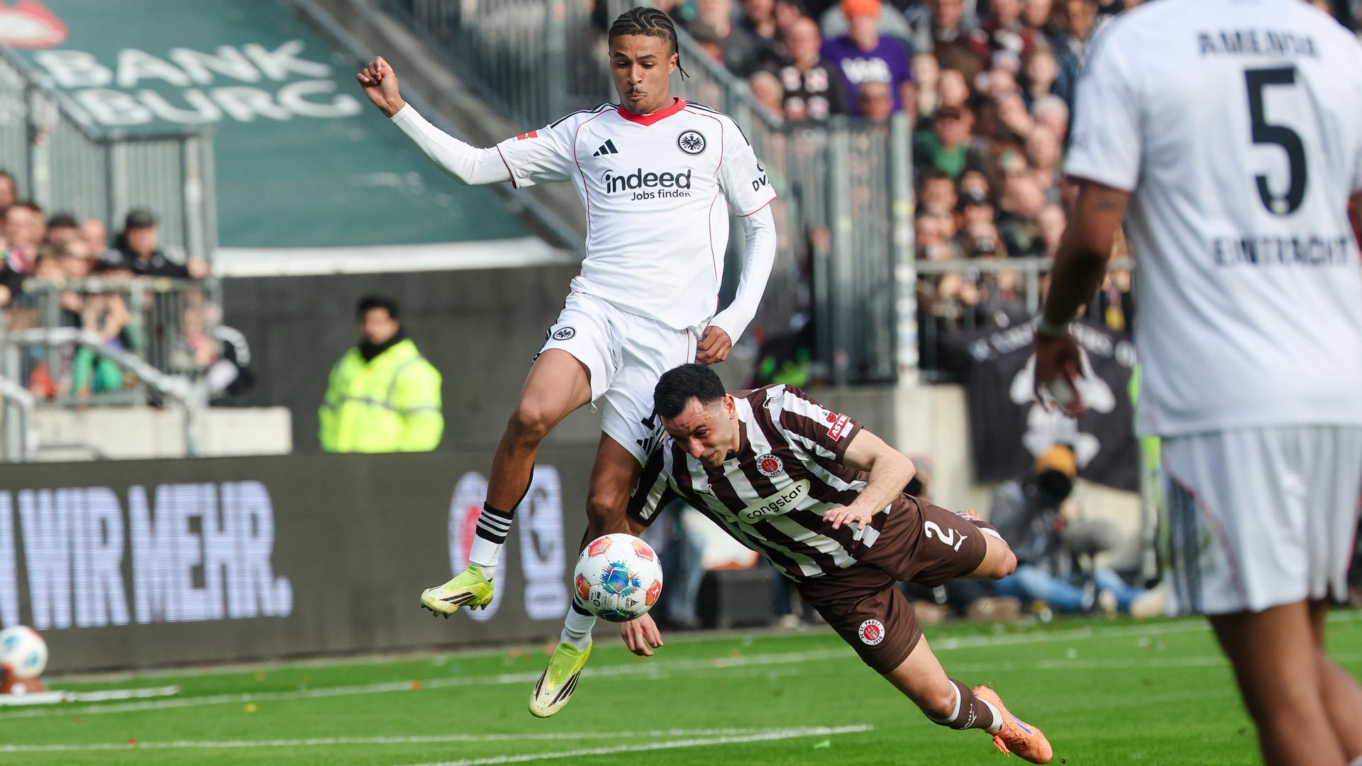 Frankfurts Flügelspieler Jean-Matteo Bahoya und St. Paulis Verteidiger Manolis Saliakas kämpfen um den Ball.