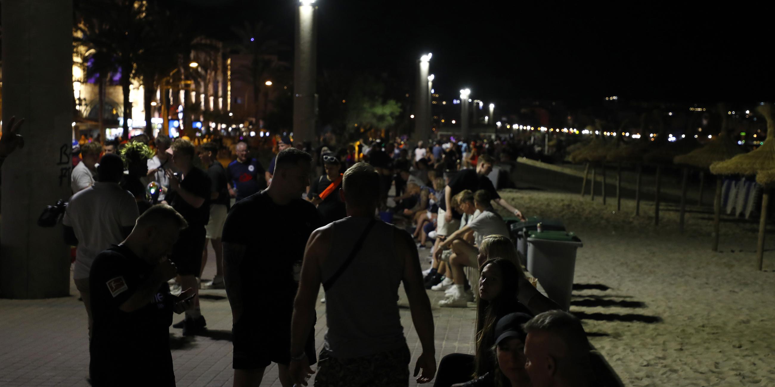 Menschen versammeln sich an der Strandpromenade von Arenal auf Mallorca.