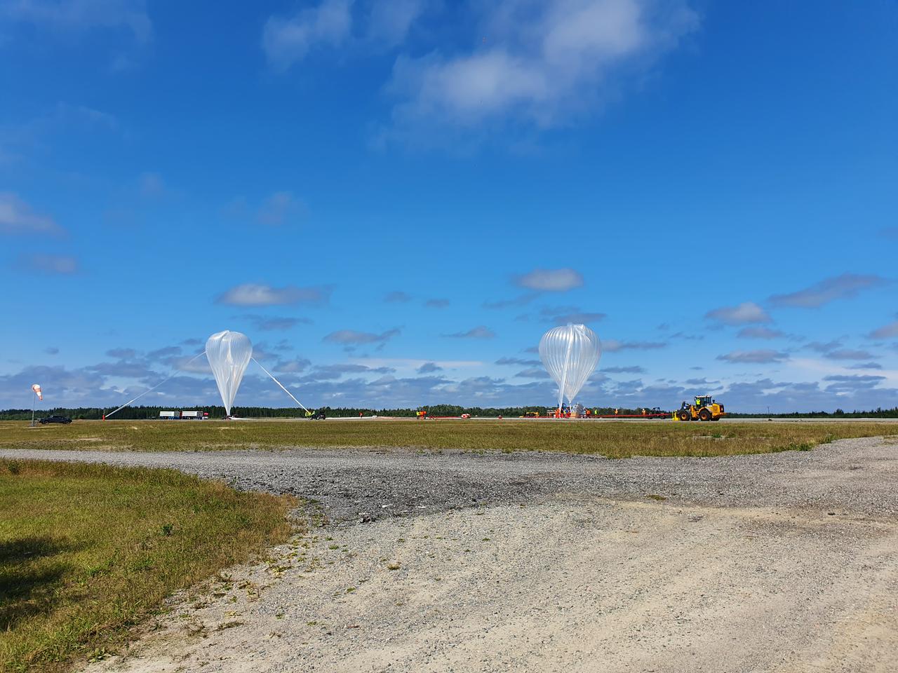 Zwei Ballons kurz vor ihrem Start auf einem Startfeld in Kanada im August 2022. Links der Hauptballon, rechts den Hilfsballon für den Start.