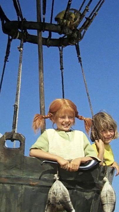 Mit Tommy und Annika geht Pippi auf große Ballonfahrt, sie schweben im Ballon in der Luft und schauen nach unten.